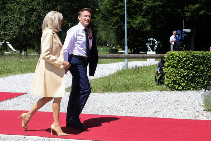 Emmanuel Macron et Brigitte Macron en trench et robe droite lors de la cérémonie d'accueil du G7,  à Krun en Allemagne, le 26 juin 2022.