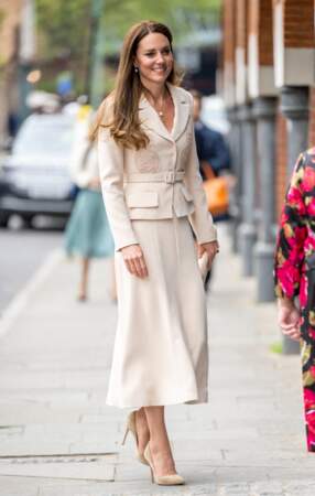 Kate Middleton dans une robe longue et beige juxtaposée d'une veste de blazer crème à Londres, le 27 avril 2022