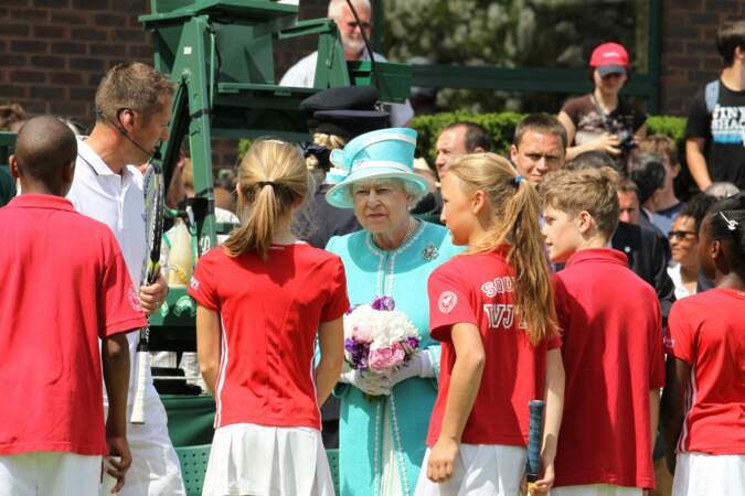 Cette année-là, la reine Elisabeth II est aperçus sur le court de tennis de Wimbledon entourée d'enfants.