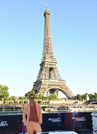 Brad Pitt pose fièrement devant la Tour Eiffel à Paris sur le bateau-mouche "L'Excellence" au Port Debilly, le 16 juillet 2022.