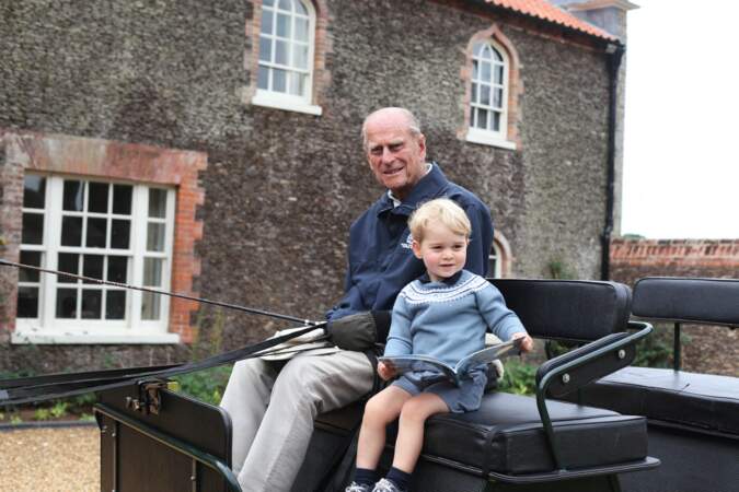 À deux ans, le prince George s'initie à l'attelage aux côté de son arrière grand-père, le prince Philip, passionné de ce sport équestre, en 2015 à Norfolk (Angleterre)