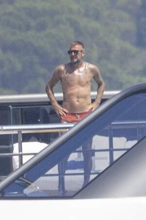 Lunettes de soleil sur le nez, bronzé et tatoué, David Beckham affiche fièrement son corps d'Apollon, le 23 juillet 2022, à Saint-Tropez.