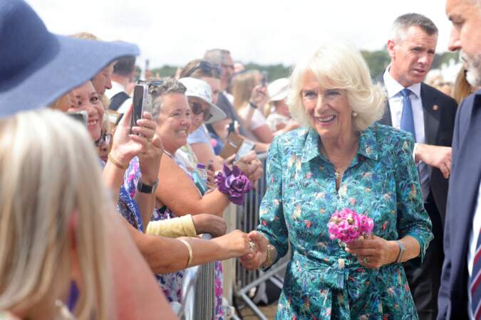 Le femme du prince Charles, Camilla Parker-Bowles, duchesse de Cornouailles, s'est approchée de  ses admirateurs une fleur à la main au Sandringham Flower Show (Royaume-Uni), le 27 juillet 2022