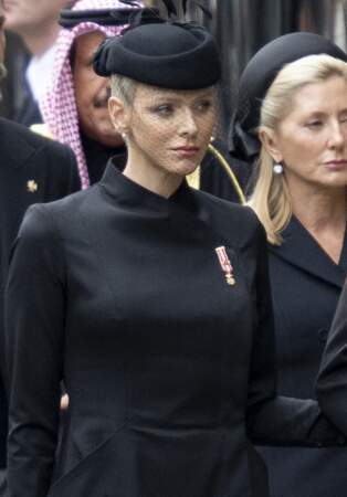 La princesse Charlene de Monaco porte le bibi noir auquel viennent se confondre quelques plumes, le 19 septembre 2022. 