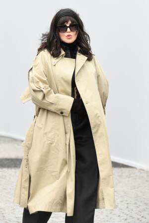 Isabelle Adjani craque pour un long trench-coats beige au défilé Dior - collection printemps/été 2023. À Paris, le 27 septembre 2022.