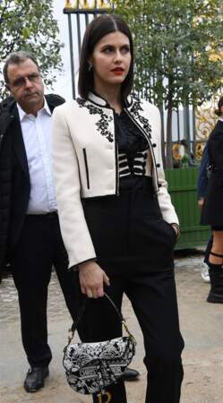 Alexandra Daddario, l'actrice américaine en veste de costume courte et mini-sac Saddle Dior au défilé Dior - collection printemps/été 2023. À Paris, le 27 septembre 2022.