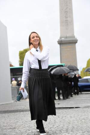 Carla Ginola en jupe plissée et chemise blanche à cravate  au défilé Dior - collection printemps/été 2023. À Paris, le 27 septembre 2022.