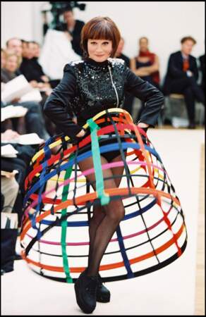 Guesch Patti porte une crinoline colorée imaginée par Jean-Charles de Castelbajac lors du défilé de prêt-à-porter automne/hiver 1998-1999 à Paris, le le 12 mars 1998