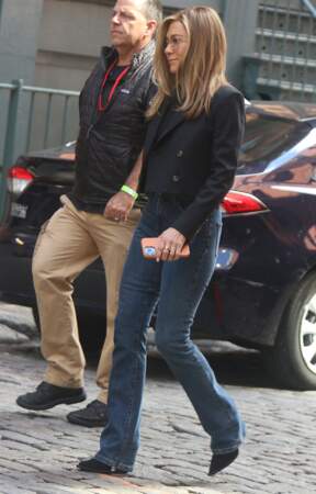 Jennifer Aniston est stylée avec une veste courte de blazer et un jean long qu'elle vient poser sur ses bottes, le 26 septembre 2022.