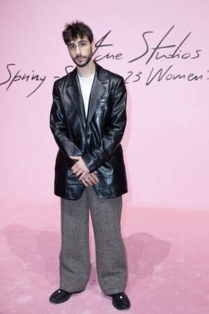 Ben Attal, l'acteur français choisit une veste de blazer large et en vinyle associée à un pantalon gris  au défilé Acne Studios à Paris, 28 septembre 2022. 
