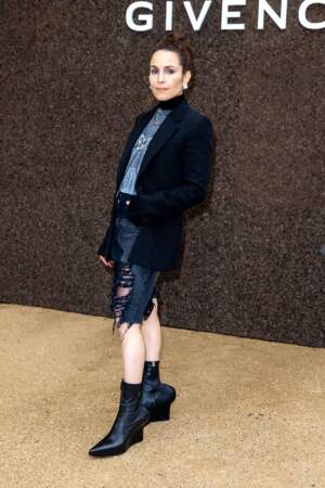 Noomi Rapace, l'actrice suédoise en short déchiré, veste de blazer et santiags lors du défilé Givenchy - collection printemps/été 2023, le 2 octobre 2022.