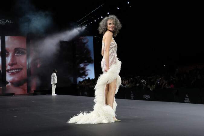 Andie MacDowell, l'actrice assume ses cheveux gris et la longue robe à plumes au défilé L'Oreal Paris à l'Ecole Militaire lors de la Fashion week - collection printemps /été 2023, le 2 octobre 2022.