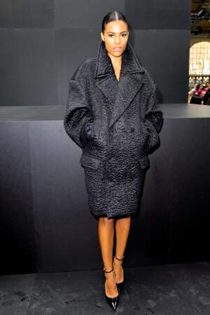 Tina Kunakey boutonne son manteau épais lors du défilé Valentino - collection printemps/été 2023, le 2 octobre 2022.