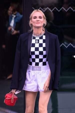 Diane Kruger porte un short de boxer lilas et un sac chanel rouge 
au défilé Chanel  - collection printemps/été 2023, le 4 octobre 2022.