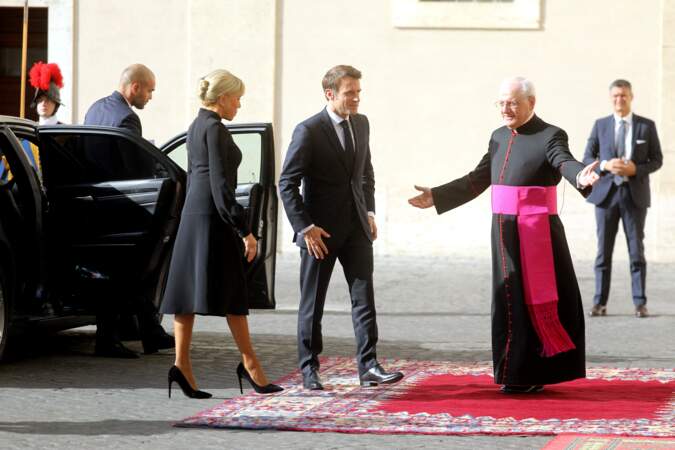 Le président Emmanuel Macron en costume noir et sa femme Brigitte en robe à col lavallière noire à Rome, le 24 octobre 2022. 