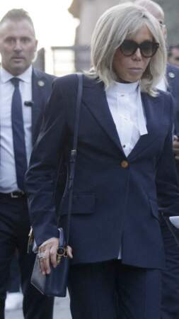 Brigitte Macron porte un sac bleu marine sur son épaule lors de sa visite du Mont Palatin, le 24 octobre 2022. 