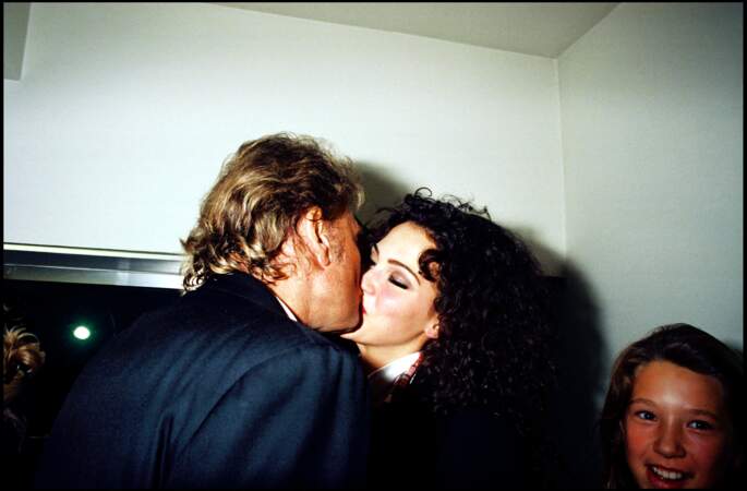 Johnny Hallyday et Linda Hardy s'embrassent fougueusement lors du défilé de mode Katoucha, à Paris, le 10 octobre 1994