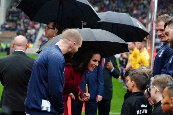 La princesse de Galles dans un manteau Alexander McQueen discute avec les enfants avant les 1/4 de finale de la Coupe du Monde de Rugby à XIII le 5 novembre 2022 à Wigan