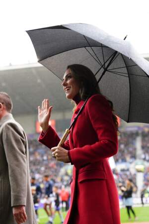 Kate Middleton a bravé la pluie dans un long trench-coat en laine rouge signé Alexander McQueen pour rencontrer l'équipe d'Angleterre de rugby avant les 1/4 de finale de la Coupe du Monde de Rugby à XIII le 5 novembre 2022 à Wigan