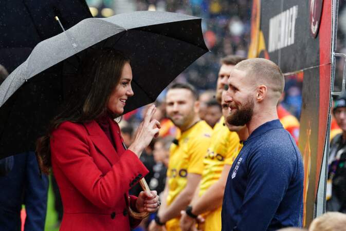 Kate Middleton portait un manteau long en laine rouge vif Alexander McQueen pour rencontrer l'équipe d'Angleterre de rugby avant les 1/4 de finale de la Coupe du Monde de Rugby à XIII le 5 novembre 2022 à Wigan