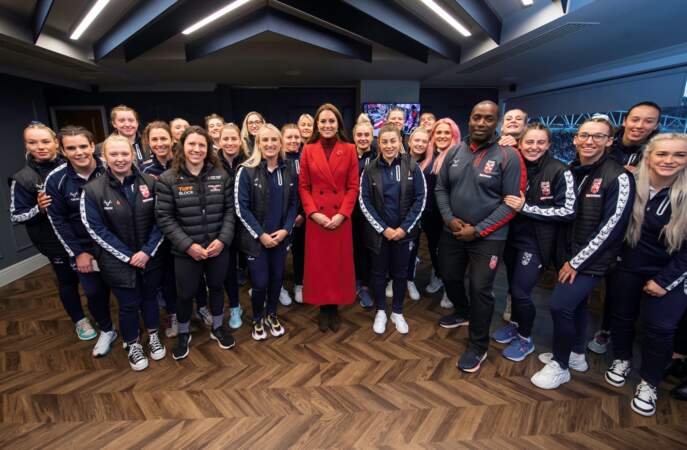 Kate Middleton dans un manteau long en laine rouge vif Alexander McQueen a rencontré l'équipe féminine de rugby d'Angleterre, lors de sa visite au stade DW à Wigan le 5 novembre 2022