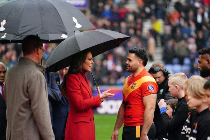 Kate Middleton dans un manteau Alexander McQueen en discussion avec l'équipe de Papouasie Nouvelle-Guinée de rugby avant les 1/4 de finale de la Coupe du Monde de Rugby à XIII le 5 novembre 2022 à Wigan