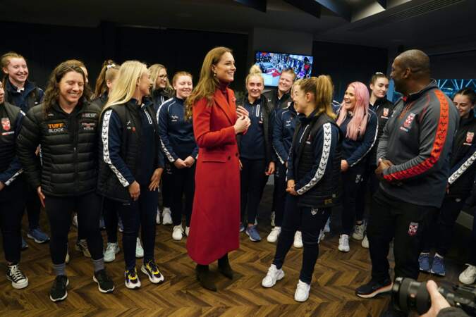 Kate Middleton dans un manteau long en laine rouge vif Alexander McQueen a discuté avec l'équipe féminine de rugby d'Angleterre, lors de sa visite au stade DW à l'occasion des 1/4 de finale de la Coupe du Monde 2022 de rugby à XIII à Wigan le 5 novembre 2022