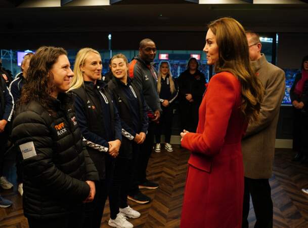 Kate Middleton dans un manteau long en laine rougeAlexander McQueen a pris le temps de discuter avec l'équipe féminine de rugby d'Angleterre, lors de sa visite au stade DW à l'occasion des 1/4 de finale de la Coupe du Monde 2022 de rugby à XIII le 5 novembre 2022 à Wigan