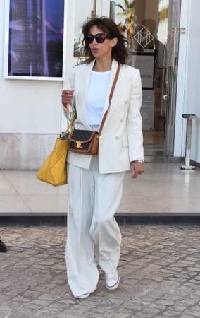 Sophie Marceau en total-look blanc à la sortie de l'hôtel Martinez à Cannes, le 9 juillet 2021. Son pantalon fluide vient épouser ses chaussures