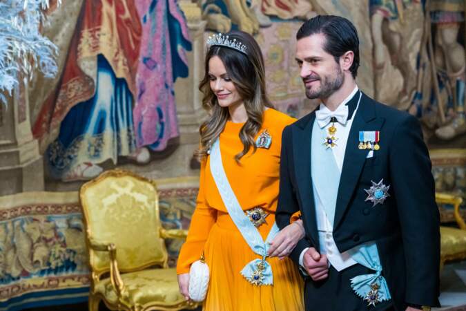 Dans une robe Lilli Jahilo et coiffée de son diadème de mariage en version perles, la princesse Sofia au bras du prince Carl Philip de Suède à leur arrivée au Palais royal à Stockholm, le 11 décembre 2022. 