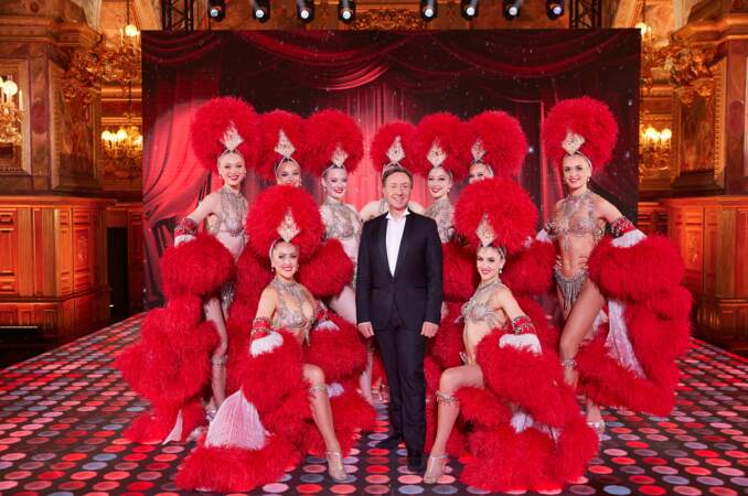 Stéphane Bern entourée des danseuses du Moulin Rouge pour "La grande soirée du 31 à Fontainebleau", le 31 décembre 2022
