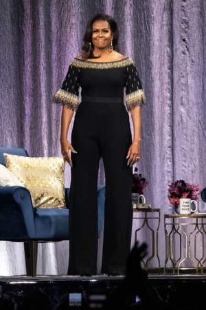 L’ancienne première dame des Etats-Unis Michelle Obama lors d'une soirée confidences pour la sortie de son livre "Becoming" à l’O2 Arena à Londres en avril 2019 porte une combinaison noire.