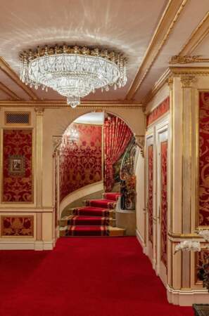 L'entrée et la cage d'escalier sont ornés de tapis rouges, les murs sont tapissés de rouge, d’or et de marbre