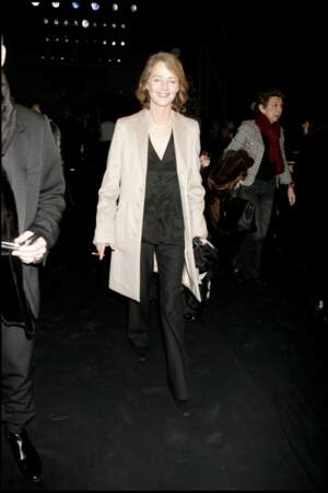 Costume noir et manteau beige contrastant, la formule d'un look réussi pour Charlotte Rampling au défilé de prêt-à-porter Dior en 2006.