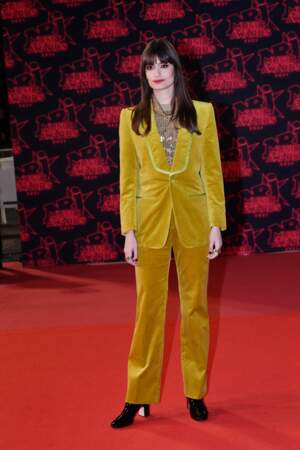 La chanteuse dans un costume en velours couleur moutarde, assorti de bottines à talons, pour les NRJ Music Awards 2021