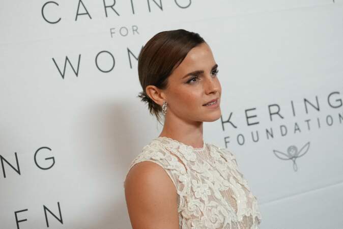Emma Watson craque pour la tendance du moment : le chignon plaqué et la raie sur le côté