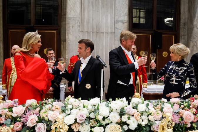 Le président Emmanuel Macron, Brigitte Macron, le roi Willem Alexander des Pays-Bas, la reine Maxima trinquent au début du dîner d'État au palais royal à Amsterdam, le 11 avril 2023