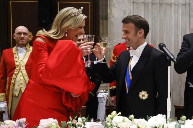 Le président Emmanuel Macron et la reine Maxima complices pour porter un toast lors du dîner d'état au palais royal à Amsterdam, le 11 avril 2023
