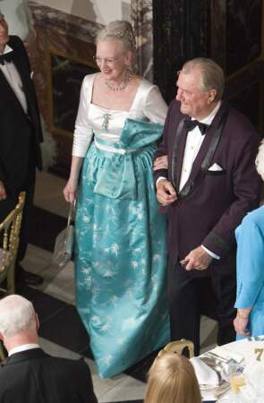 Margrethe II dans une robe émeraude nouée à la taille, se tenant au bras du prince Henrik lors d'un banquet royal au château de Fredensborg en juin 2009 pour fêter les 75 ans de son mari