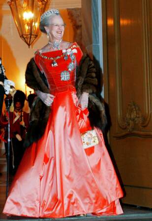 Margrethe II de Danemark à Copenhague dans une robe couleur corail au bustier assorti et sur lequel trône ses nombreuses distinctions