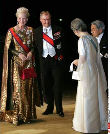 La reine très élégane dans une robe dorée à cape, avec son mari le prince Henrik pour rencontrer l'impératrice Michiko et l'empereur Akihito à Tokyo en novembre 2004