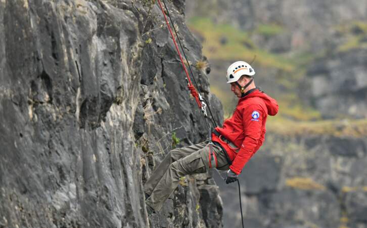 Le prince William lors d'une descente en rappel, le long d'une paroi rocheuse à l'aide d'une corde.