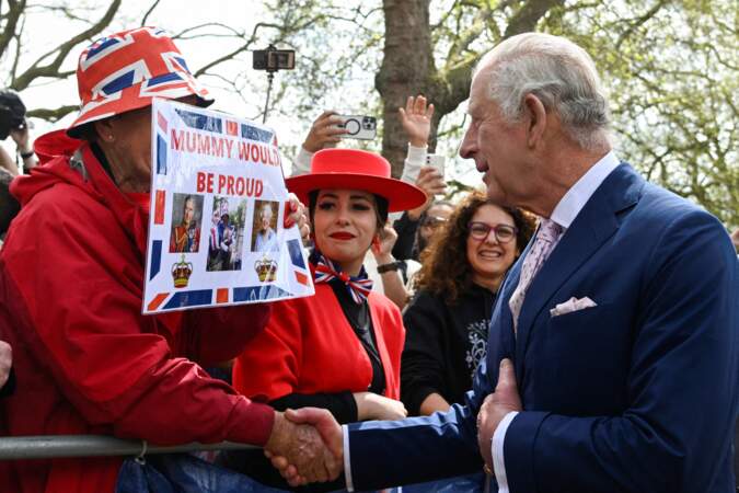 Charles III, heureux, qui serre la main d'un sympathisant américain, devant le palais de Buckingham, à la veille de son couronnement, le 5 mai 2023.