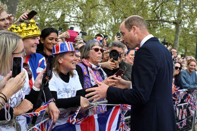 Le prince William en plein échange avec une sympathisante, devant Buckingham Palace, à la veille du couronnement de Charles III. Vendredi 5 mai 2023.