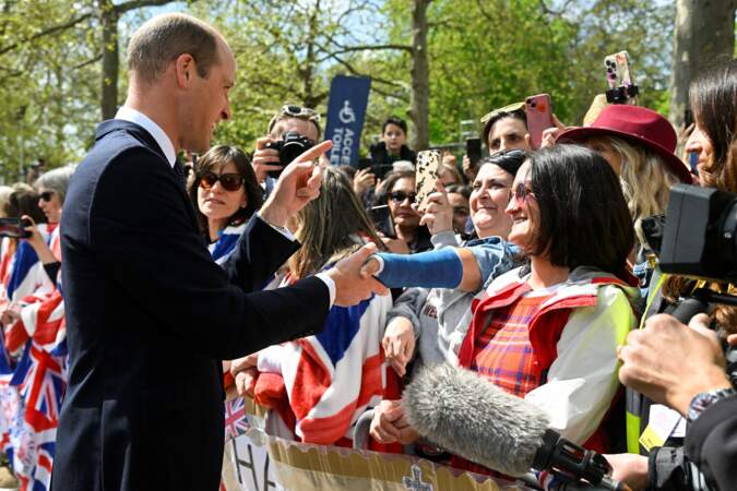 Le prince William qui serre la main d'une sympathisante, présente devant Buckingham Palace, à la veille du couronnement de son père. Vendredi 5 mai 2023.
