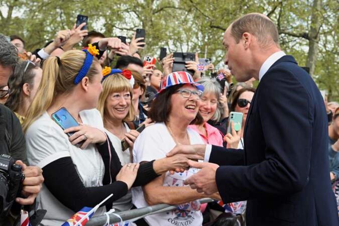 Le prince William en plein échange avec une sympathisante, devant Buckingham Palace, à la veille du couronnement de son père. Vendredi 5 mai 2023.
