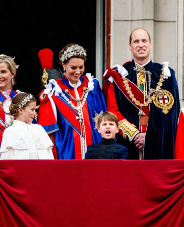 Avec ses pitreries, le prince Louis amuse sa mère Kate Middleton et sa grande sœur Charlotte sur le balcon de Buckingham Palace, le 6 mai 2023