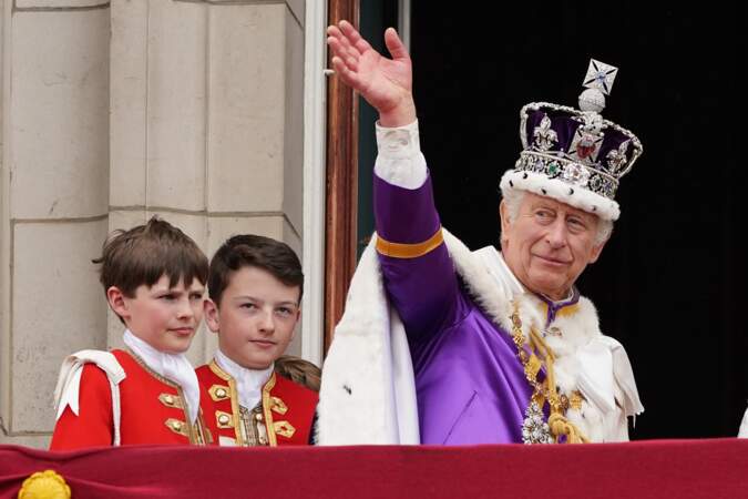 Entouré de ses pages, le roi Charles III salue une dernière fois la foule venue l'acclamer devant Buckingham Palace, le 6 mai 2023