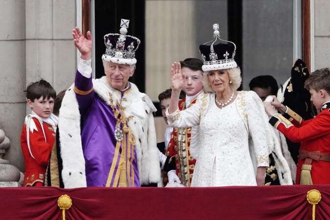 Quelques heures après leur couronnement, le roi Charles III et la reine consort Camilla Parker Bowles saluent la foule, le 6 mai 2023