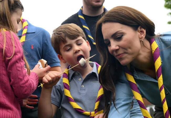 Le prince George, le prince Louis, la princesse Charlotte et Kate Middleton en joie à l'idée de déguster des marshmallows après avoir pris part aux rénovations d'un camp scout dans le Berkshire pour le Big Help Out.